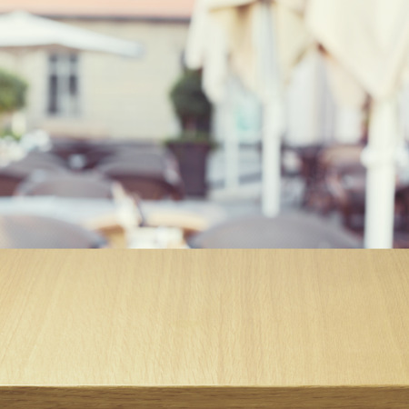 Wooden table over outdoor restaurant blur 