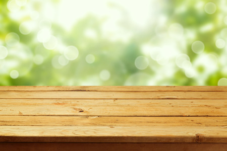 Empty wooden deck table over garden bokeh background. Ready for product montage displayの写真素材