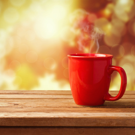 Red coffee cup over autumn backgroundの写真素材