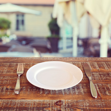 Restaurant background with empty plate and silverwareの写真素材