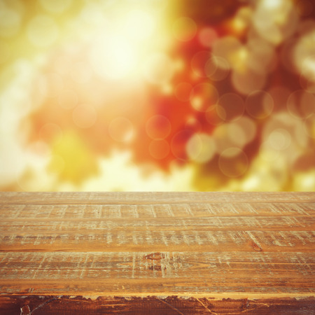 Autumn background with beautiful bokeh and wooden tableの写真素材