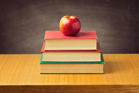 Apple on old vintage books over chalkboardの写真素材