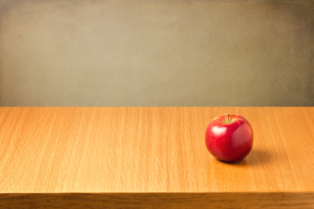 Apple on wooden table over grunge backgroundの写真素材