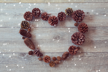 Heart shape frame from pine corn on wooden backgroundの写真素材