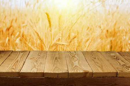 Wheat field background and empty wooden deck tableの写真素材