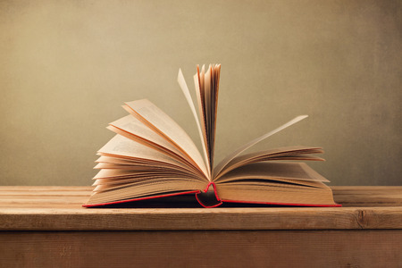 Open old book on wooden tableの写真素材