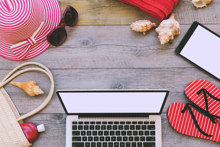 Summer holiday background with laptop and beach items. View from aboveの写真素材
