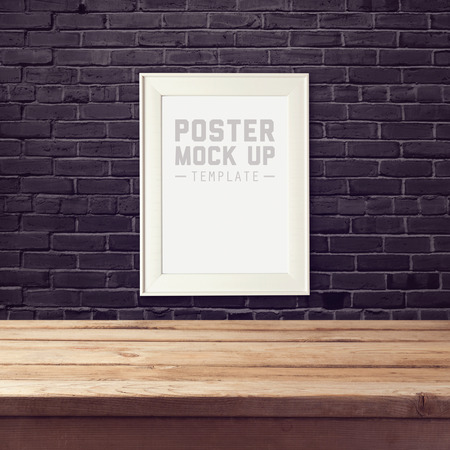 Modern poster mock up template with wooden table over brick black wallの写真素材