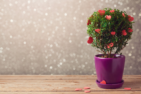 Tree plant with hearts on wooden table over bokeh background. Valentine's day conceptの写真素材