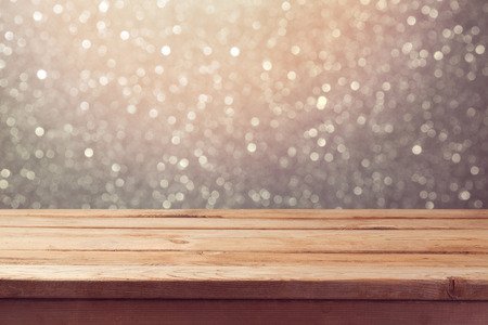 Festive background with empty wooden table over glitter bokeh lightsの写真素材