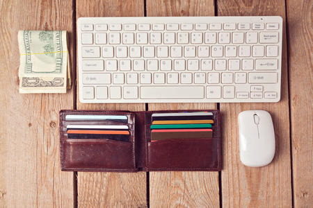 Online shopping concept with wallet, money and keyboard on wooden background. View from aboveの写真素材