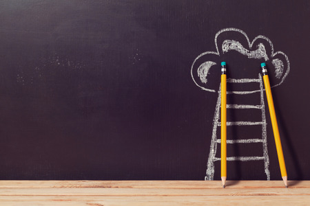 Success concept with pencils and ladder over chalkboardの写真素材