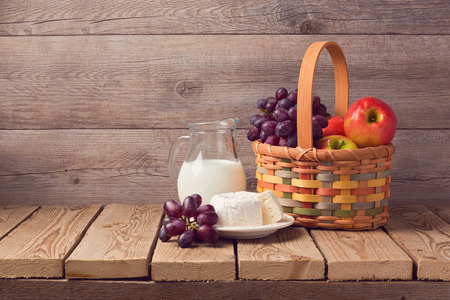 Milk, cheese and fruit basket on wooden rustic table. Jewish holiday Shavuot celebrationの写真素材