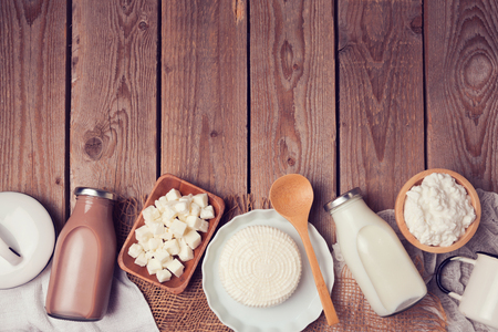 Milk and cheese on wooden background. View from above. Flat layの写真素材