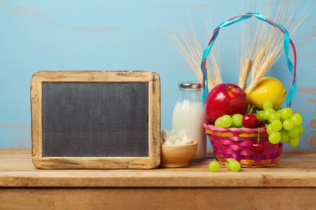 Jewish holiday Shavuot celebration with milk and fruits basket on wooden table.の写真素材