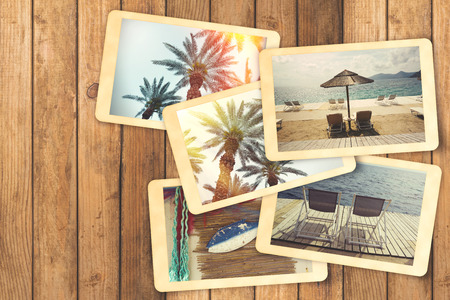 Summer holiday vacation photo album with retro instant photos on wooden tableの写真素材