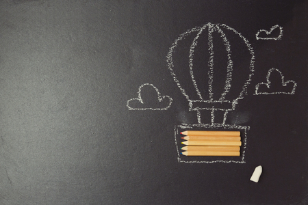 Back to school background with air balloon made from pencils on black boardの写真素材
