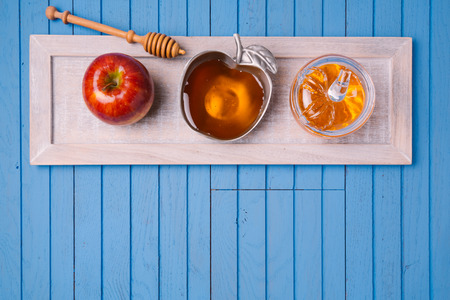 Jewish holiday Rosh Hashana still life with honey and apples on wooden blue table. View from above. Flat layの写真素材