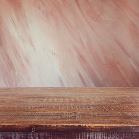 Empty wooden table over painted marsala color wall backgroundの写真素材