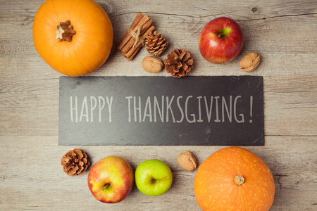 Thanksgiving holiday concept with pumpkin, apples and walnuts on wooden tableの写真素材