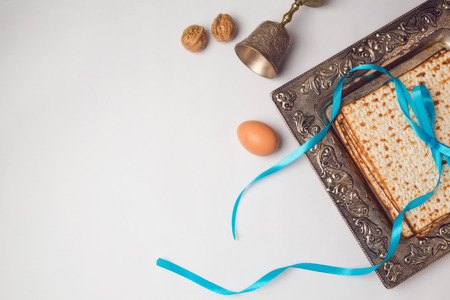 Jewish holiday Passover concept with matzah, egg and wine glass on white background. View from above. Flat layの写真素材
