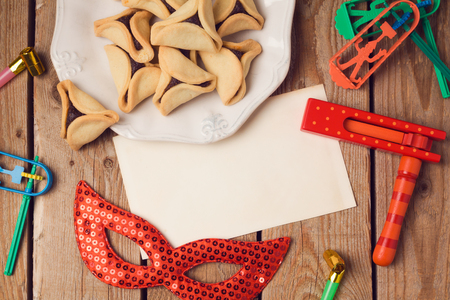Purim holiday concept with  greeting card and hamantaschen cookies on wooden background. Top view from aboveの写真素材
