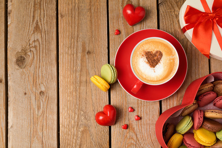 Valentines day concept with macarons and coffee cup over wooden background. Top view from aboveの写真素材