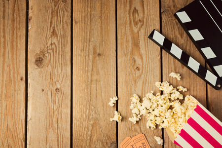 Movie clapper board and popcorn on wooden background. Top view from aboveの写真素材