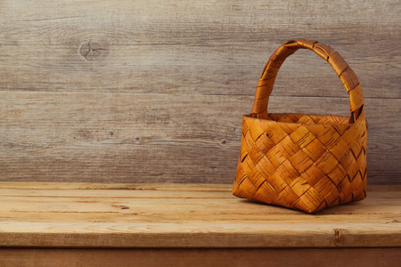 Picnic basket tablecloth on wooden table over rustic backgroundの写真素材