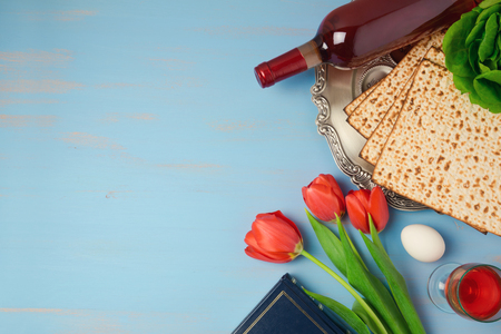 Passover holiday concept seder plate, matzoh and tulip flowers on wooden background. Top view from aboveの写真素材