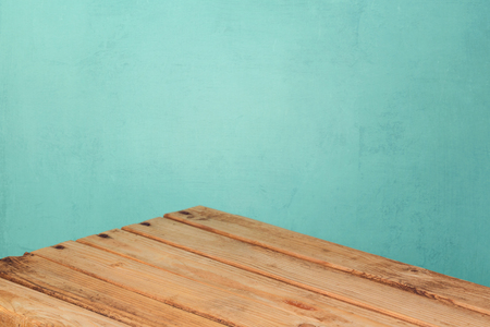 Empty wooden corner table over mint wall background for product montage displayの写真素材