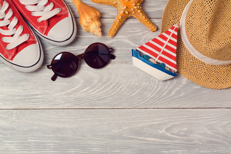 Summer vacation background with shoes, sunglasses and hat on wooden board. View from aboveの写真素材