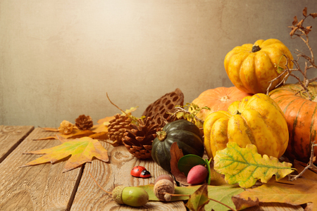 Autumn background with fall leaves and pumpkin on wooden tableの写真素材