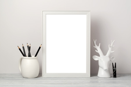 White frame mock up with pencil and decor deer. Modern stylish interior background for social media...
