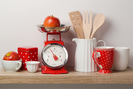 Kitchen shelf with scales and kitchen utensils over white wall backgroundの写真素材