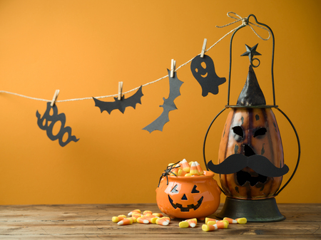 Halloween background with decor jack o lantern and candy corn on wooden tableの写真素材