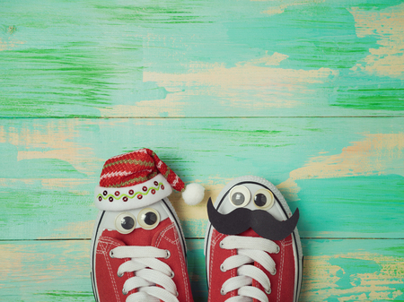 Christmas holiday concept. Sneakers shoes with santa hat and mustache. View from aboveの写真素材