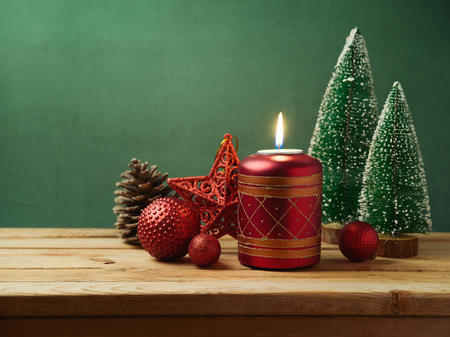 Christmas holiday background with candle and decorations on wooden rustic tableの写真素材