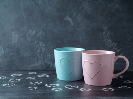 Valentines day concept with cups and  heart shapes over chalkboard backgroundの写真素材