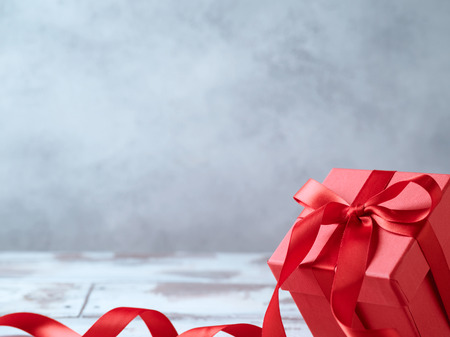 Gift box with red ribbon over grey backgroundの写真素材