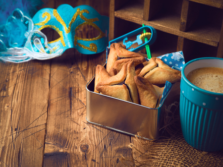 Hamantaschen cookies in box over rustic background with coffee cup. Purim holiday celebration.の写真素材