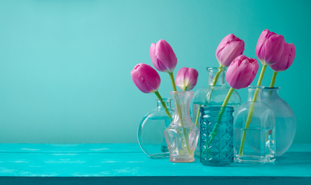 Tulip flowers in vases over blue background. Mother's day or women day holiday celebration.の写真素材