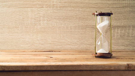 Hourglass on wooden table. Countdown to a deadline concept