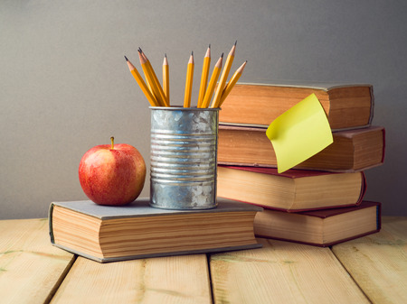 Back to school concept with pencils, apple and old books on wooden tableの写真素材
