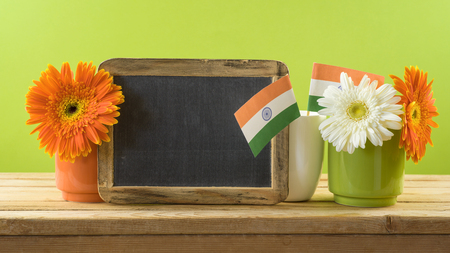 India Independence day background with indian flag, chalkboard and flowers.