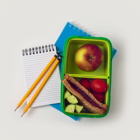 Back to school concept with healthy snack and notebooks on white background. View from aboveの写真素材