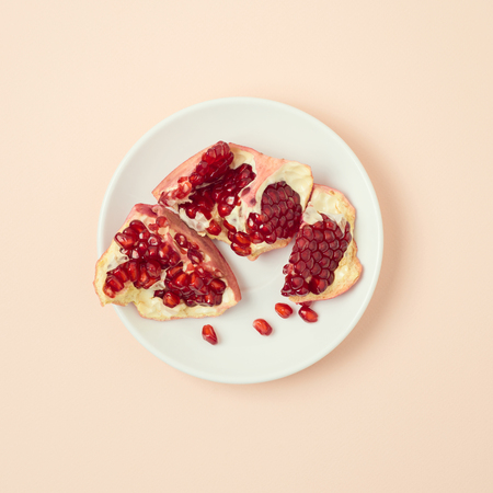 Pomegranate on plate on bright background. Minimal concept. Flat layの写真素材