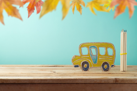 Back to school concept with cardboad bus and pencils on wooden table over blue backgroundの写真素材