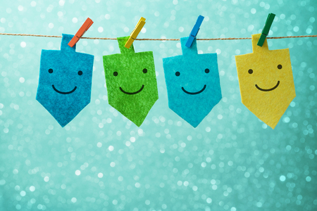 Jewish holiday Hanukkah concept with spinning top dreidel decor with funny faces over bokeh backgroundの写真素材