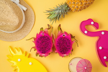 Tropical summer background with dragon fruit , pineapple and party flamingo decor. View from above....